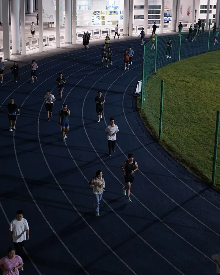 Grupo de pessoas treinando numa pista de atletismo
