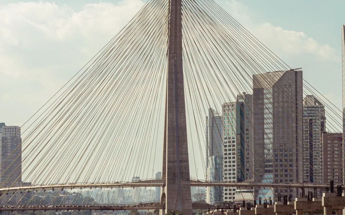 Ponte estaiada e prédios de São Paulo refletidos no rio